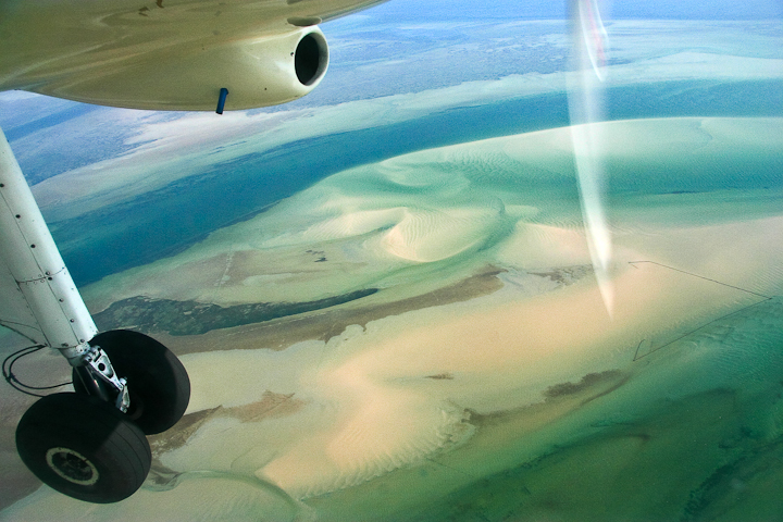 *Anflug nach Pomene* <br><br> Beim Anflug auf Pomene sieht man die zahlreichen Sandbänke vor der Küste. <br><br>