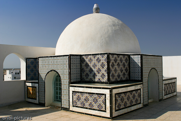 *Typische Kacheln in Kairouan* <br><br> Tja - typisch sind sie zwar schon, aber leider nicht mehr sehr häufig zu finden. Aber beinahe unbemerkt von dem Trubel an Tunesiens Stränden trotzt die Kairouan, die heilige Stadt des Maghreb, der Moderne. Hier lebt man im Rhythmus des Islams. Die Zeit scheint stehengeblieben zu sein in den verwinkelten Souks, im Labyrinth der Gassen und Gänge.

Mehrmals täglich kann man dort das Konzert unzähliger Muezzine von den über 100 Minaretten tönen hören: der Klang eines intakten, arabisch-islamischen Altstadtensembles. <br><br>