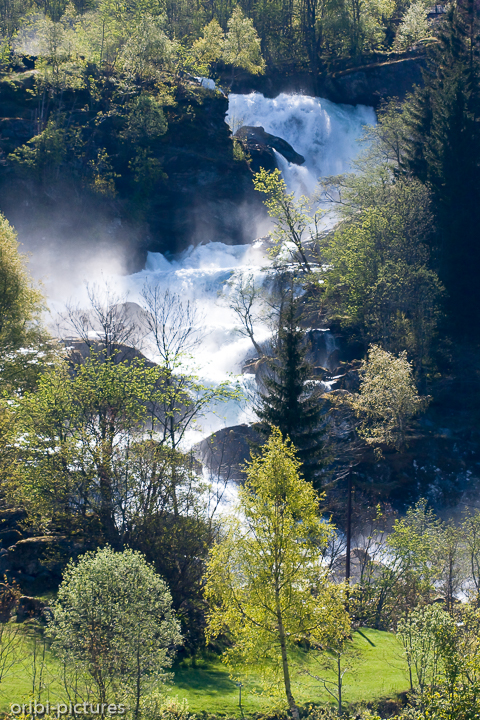 *Wasserfall über dem Ort Geiranger*<br><br>Die Gischt steigt auf, bei den herabstürzenden Wassermassen nach den Wintermonaten.<br><br>